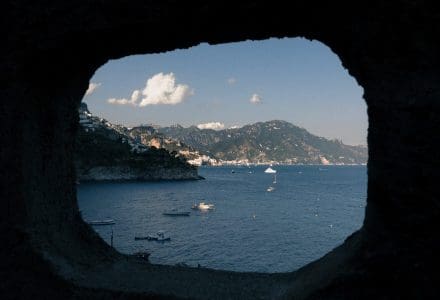 view through a rock of boats in italy