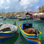 view of boats in a harbour in a small town on a malta yacht charter