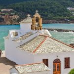 view of a church and the ocean on the island of Skopelos on a greek islands catamaran charter