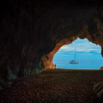 rocks formations and cave with a sailing boat