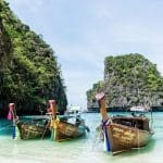 boats on a thailand yacht charter in Phuket with limestone mountains