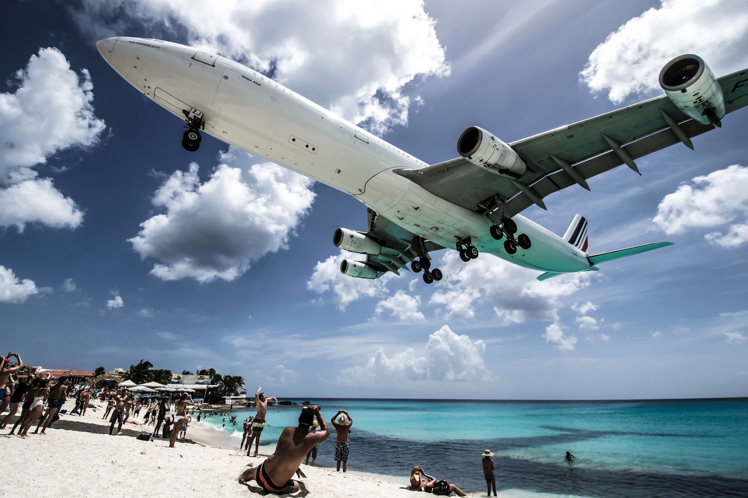 plane flying over a beach close to airport in st Maarten