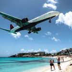 plane flying over a beach close to airport in st Maarten