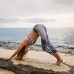 girl doing yoga on a beach